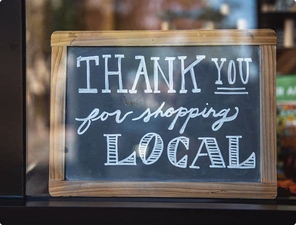 sign in window that says thank you for shopping local
